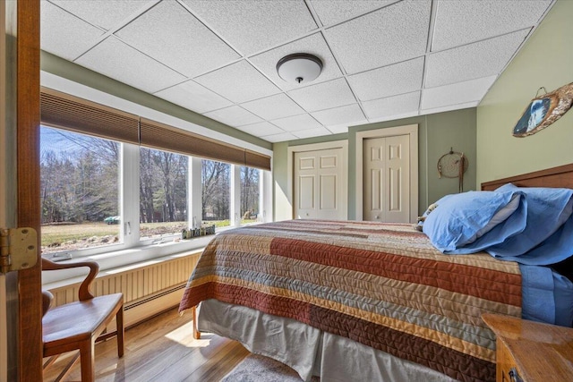 374 Youngs Ridge Rd, Acton, ME 04001 - bedroom featuring wood finished floors, a paneled ceiling, and a baseboard heating unit