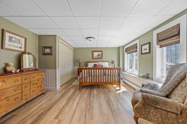 374 Youngs Ridge Rd, Acton, ME 04001 - bedroom with light wood-style flooring, a drop ceiling, baseboard heating, a closet, and wainscoting