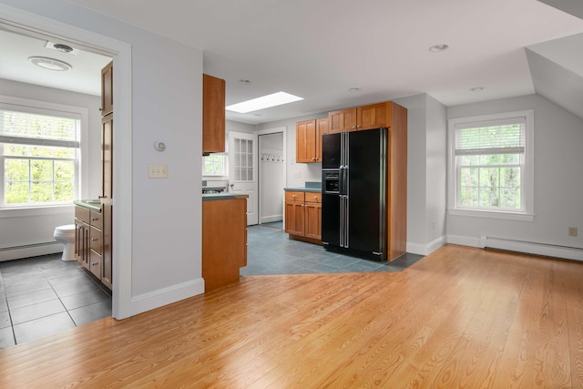 72 Natures Way, Wells, ME 04090 - kitchen with black fridge with ice dispenser, baseboard heating, a skylight, baseboards, and vaulted ceiling