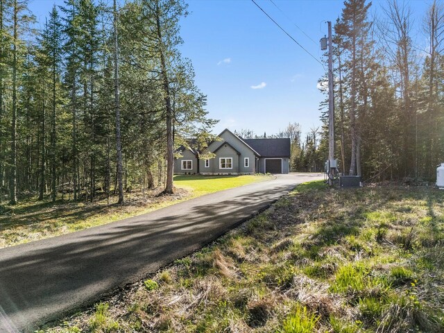 view of front of property featuring driveway, an attached garage, and a front lawn