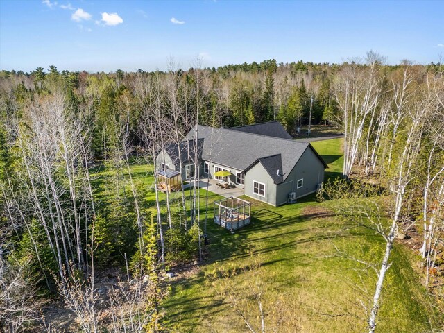 aerial view of property and surrounding area featuring a heavily wooded area