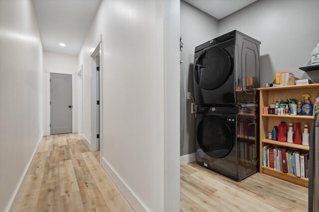 washroom with stacked washer / dryer, wood finished floors, baseboards, and recessed lighting