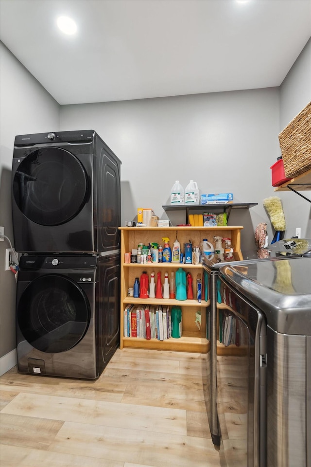 laundry room featuring stacked washing machine and dryer and wood finished floors