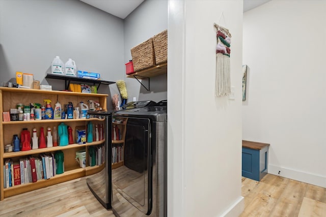 washroom featuring wood finished floors, washer and clothes dryer, and baseboards