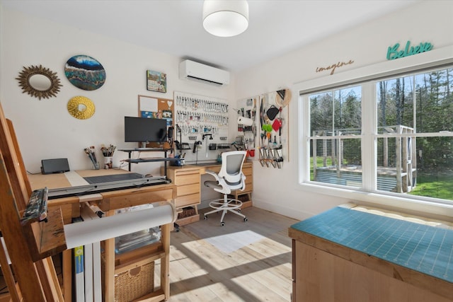 office with a wall mounted air conditioner, healthy amount of natural light, light wood-style flooring, and baseboards
