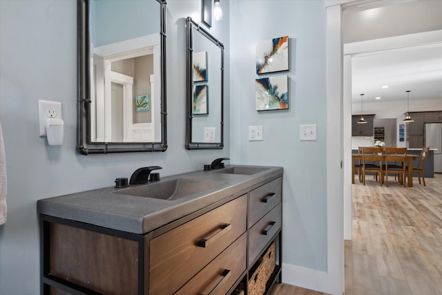 full bathroom featuring wood finished floors, double vanity, and recessed lighting