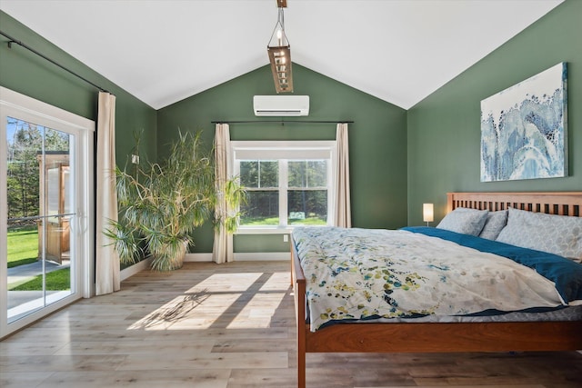 bedroom with multiple windows, access to exterior, a wall unit AC, and vaulted ceiling