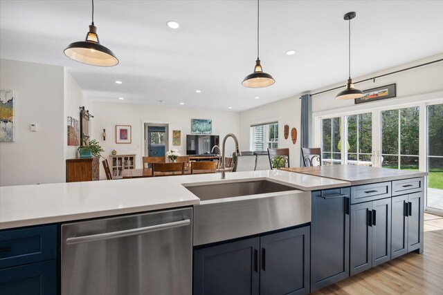 kitchen with dishwasher, a sink, light countertops, pendant lighting, and recessed lighting