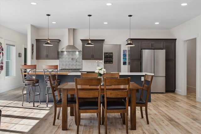 dining area featuring light wood-style floors, recessed lighting, and baseboards