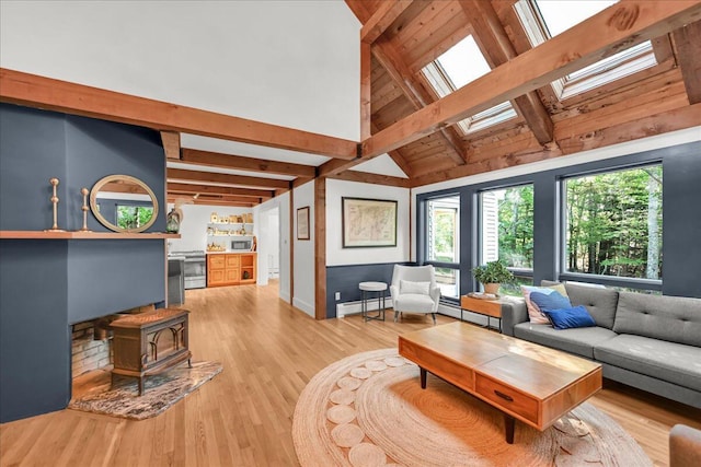 29 Penny Ln, Blue Hill, ME 04614 - living room featuring a baseboard heating unit, a wood stove, beam ceiling, a skylight, and light wood finished floors