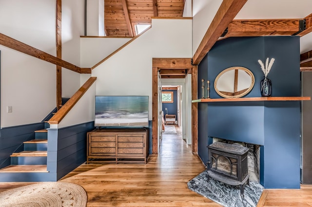 29 Penny Ln, Blue Hill, ME 04614 - staircase with wood finished floors, a wainscoted wall, a towering ceiling, and a wood stove