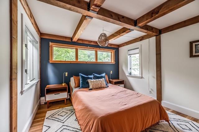 29 Penny Ln, Blue Hill, ME 04614 - bedroom featuring baseboards, beam ceiling, multiple windows, and wood finished floors