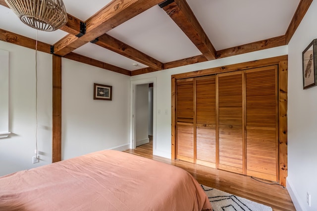 29 Penny Ln, Blue Hill, ME 04614 - bedroom with baseboards, a closet, wood finished floors, and beam ceiling