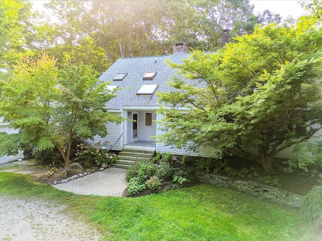 29 Penny Ln, Blue Hill, ME 04614 - view of front facade with covered porch, a front yard, a shingled roof, and a chimney