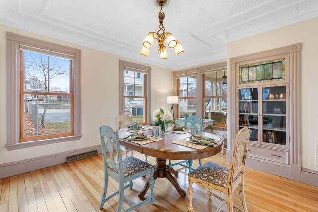 28 Saco Ave, Old Orchard Beach, ME 04064 - dining room featuring light wood finished floors, a notable chandelier, ornamental molding, and visible vents