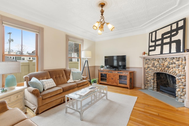 28 Saco Ave, Old Orchard Beach, ME 04064 - living area with light wood-style floors, a healthy amount of sunlight, a fireplace, and wainscoting