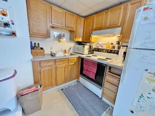 160 Washington Ave, Portland, ME 04101 - kitchen featuring white appliances, under cabinet range hood, light countertops, a sink, and light brown cabinetry