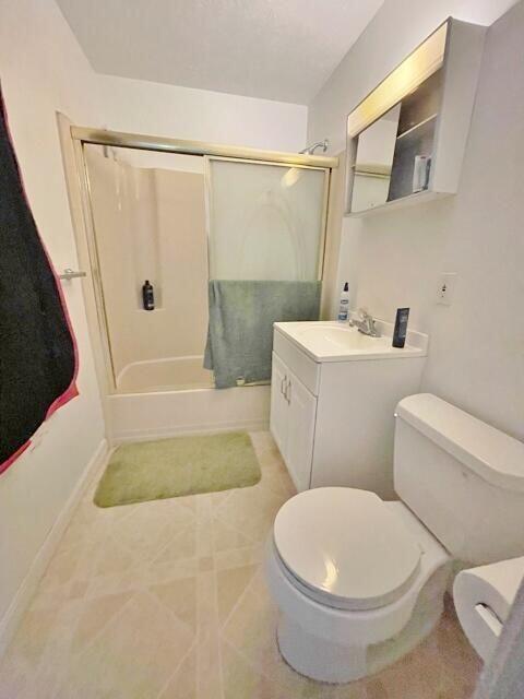 160 Washington Ave, Portland, ME 04101 - bathroom with toilet, bath / shower combo with glass door, baseboards, vanity, and tile patterned floors