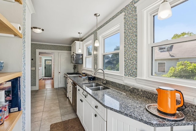 53 Ocean View Ave, South Portland, ME 04106 - kitchen with white cabinetry, appliances with stainless steel finishes, light tile patterned floors, hanging light fixtures, and dark stone countertops