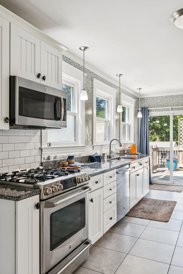 53 Ocean View Ave, South Portland, ME 04106 - kitchen featuring appliances with stainless steel finishes, plenty of natural light, white cabinetry, and light tile patterned floors