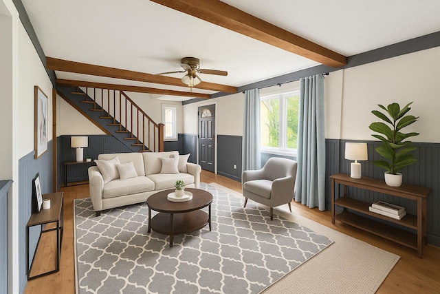 27 Cannard St, Gardiner, ME 04345 - living room featuring plenty of natural light, wainscoting, beam ceiling, wood finished floors, and stairs