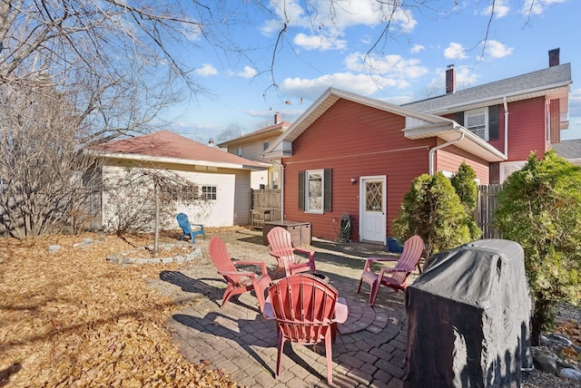 218 Bradley St, Portland, ME 04103 - back of property featuring a fire pit, a patio area, fence, and an outbuilding