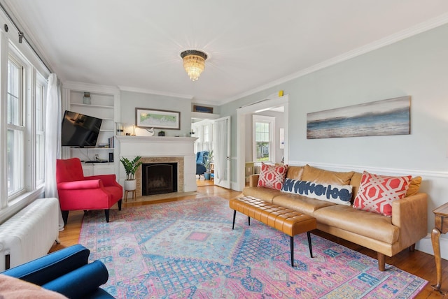 218 Bradley St, Portland, ME 04103 - living area featuring radiator, wood finished floors, crown molding, and a fireplace