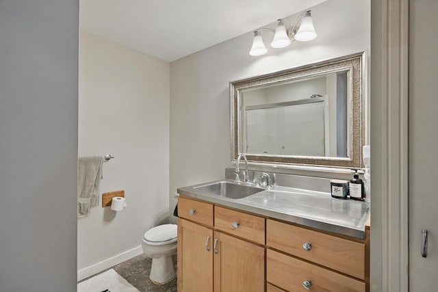 bathroom with vanity, toilet, and baseboards