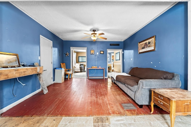 living room with crown molding, baseboards, a textured ceiling, hardwood / wood-style flooring, and ceiling fan