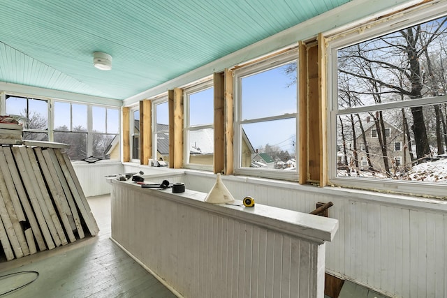 sunroom with hardwood / wood-style flooring and wainscoting