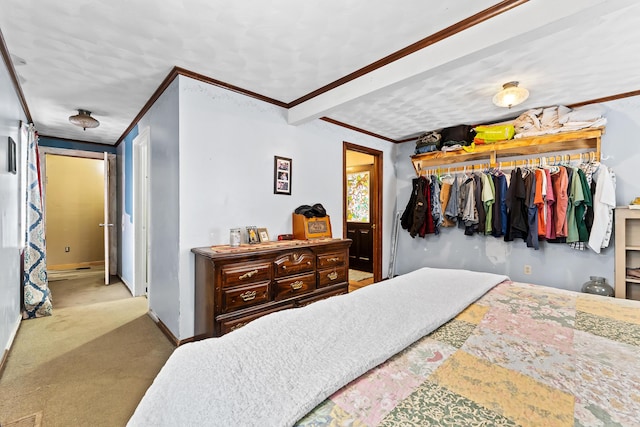 carpeted bedroom featuring ornamental molding, baseboards, and a closet