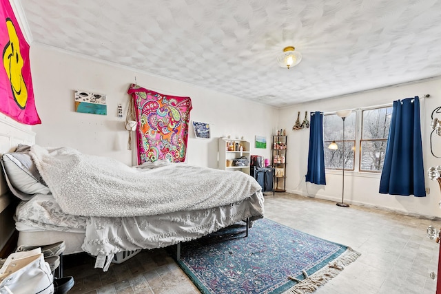 bedroom with baseboards and a textured ceiling