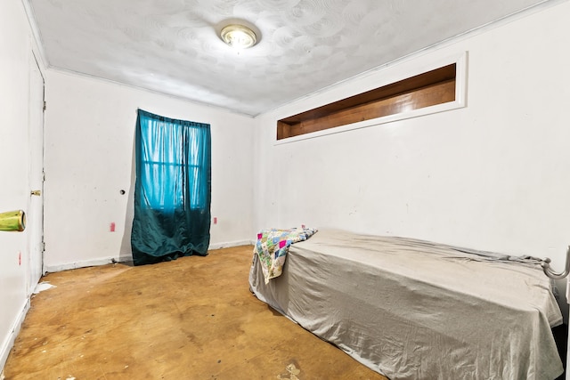 bedroom with baseboards and concrete flooring