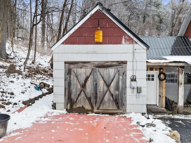 snow covered structure featuring an outdoor structure and a barn
