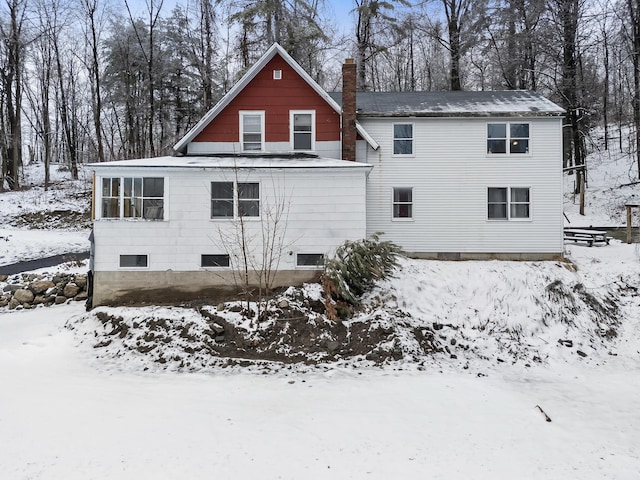 snow covered property with a chimney