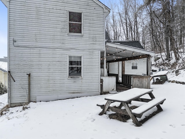 view of snow covered rear of property
