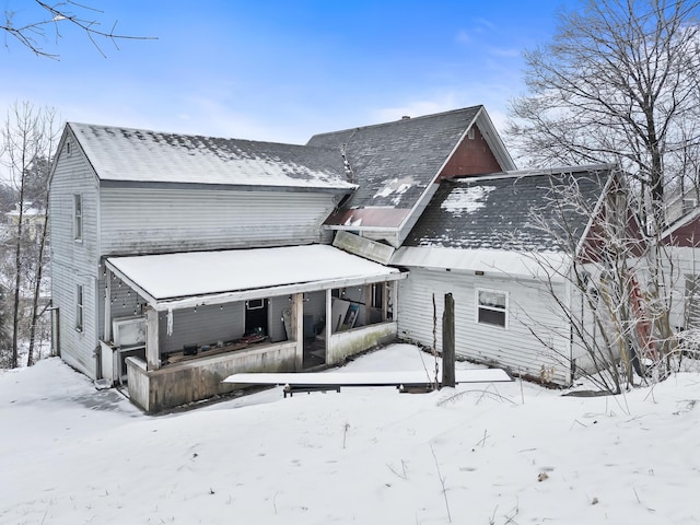 view of snow covered back of property