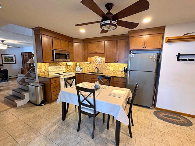 1873 Sly Brook Rd, Eagle Lake, ME 04739 - kitchen with appliances with stainless steel finishes, ceiling fan, a sink, decorative backsplash, and brown cabinetry