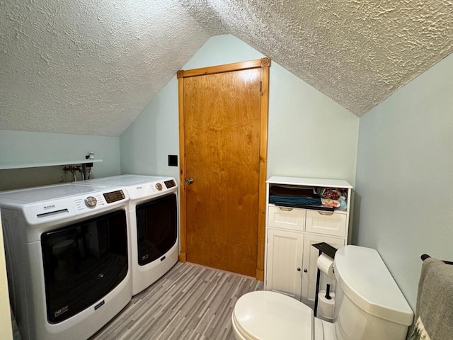 1873 Sly Brook Rd, Eagle Lake, ME 04739 - washroom featuring washer and clothes dryer, light wood-style floors, and a textured ceiling