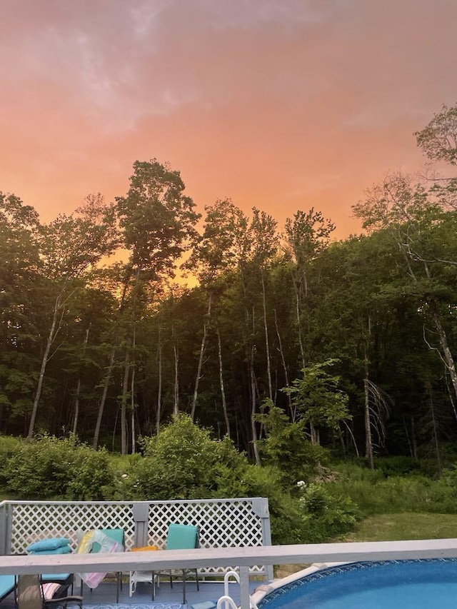 pool at dusk with outdoor dining space