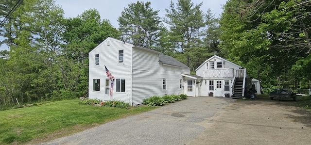 749 W River Rd, Waterville, ME 04901 - dutch colonial with a front yard, asphalt driveway, and view of wooded area