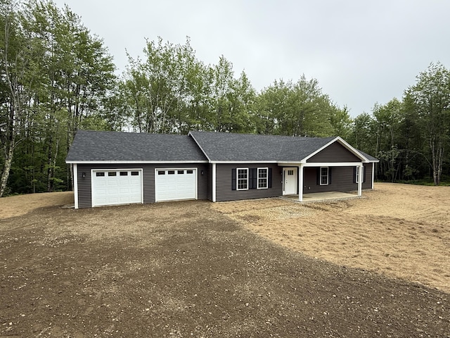 6 Bramble Ln, Windsor, ME 04363 - single story home with a garage, dirt driveway, a porch, and a shingled roof