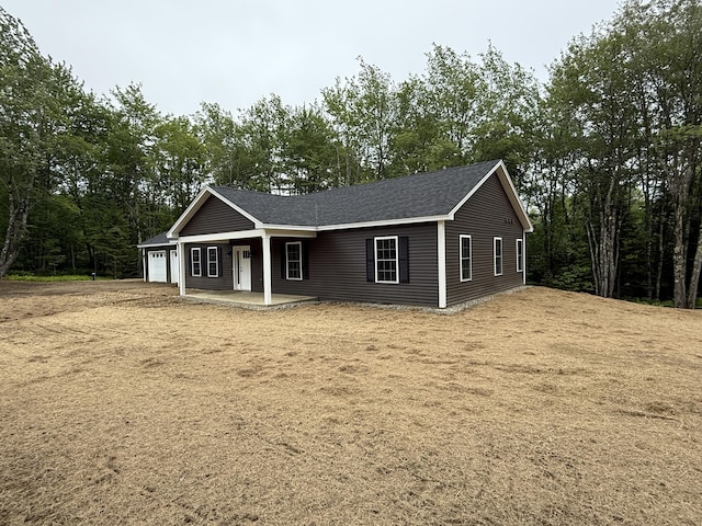 6 Bramble Ln, Windsor, ME 04363 - view of front of house with an attached garage, a porch, and a shingled roof