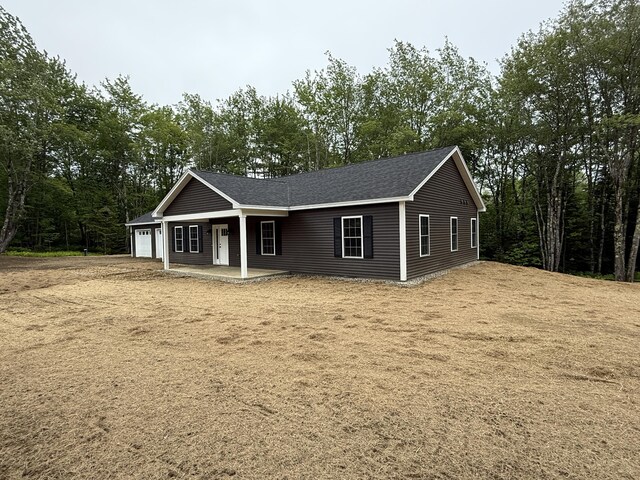 6 Bramble Ln, Windsor, ME 04363 - view of front of house with an attached garage, a porch, and a shingled roof