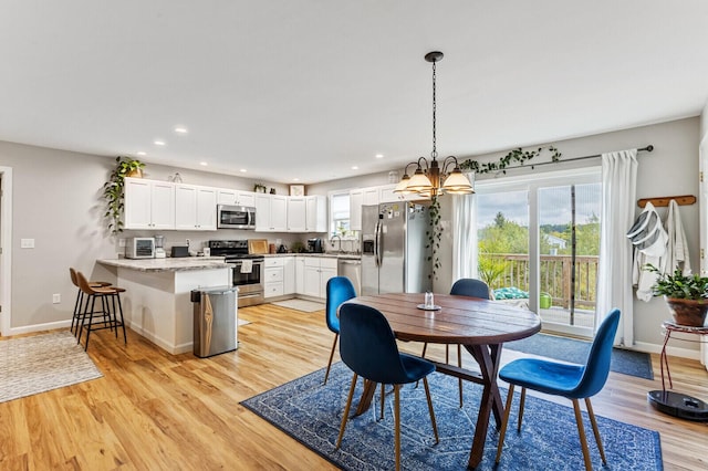 dining space with baseboards, light wood-style flooring, recessed lighting, and a chandelier