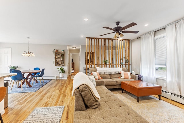 living area with baseboard heating, recessed lighting, ceiling fan with notable chandelier, and wood finished floors