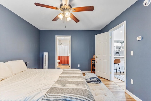 bedroom featuring baseboards, ceiling fan, stainless steel refrigerator with ice dispenser, and light wood finished floors