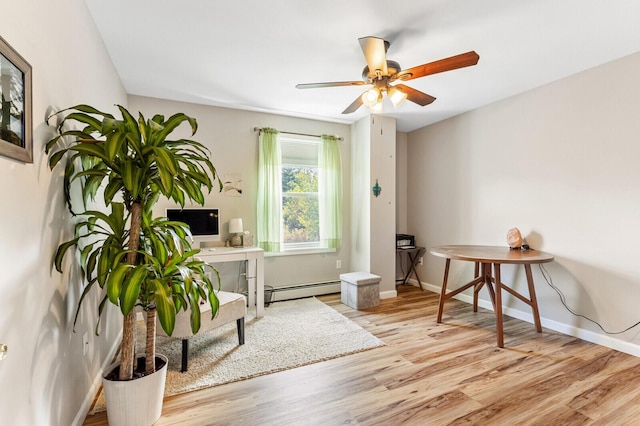 home office with baseboards, a baseboard radiator, wood finished floors, and a ceiling fan