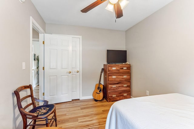 bedroom with light wood-style flooring, baseboards, and ceiling fan
