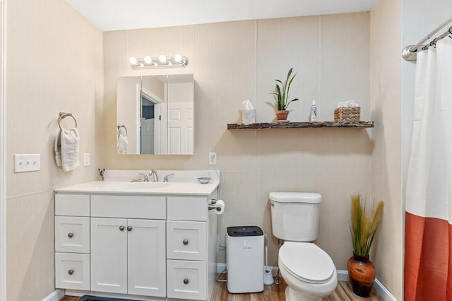 full bathroom with toilet, vanity, baseboards, and wood finished floors